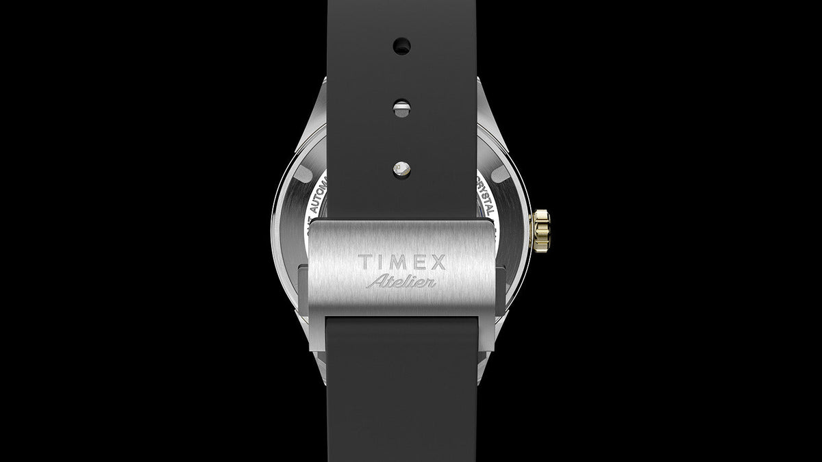 Rear view of the black rubber strap and brushed stainless-steel clasp engraved with the Timex Atelier logo.
