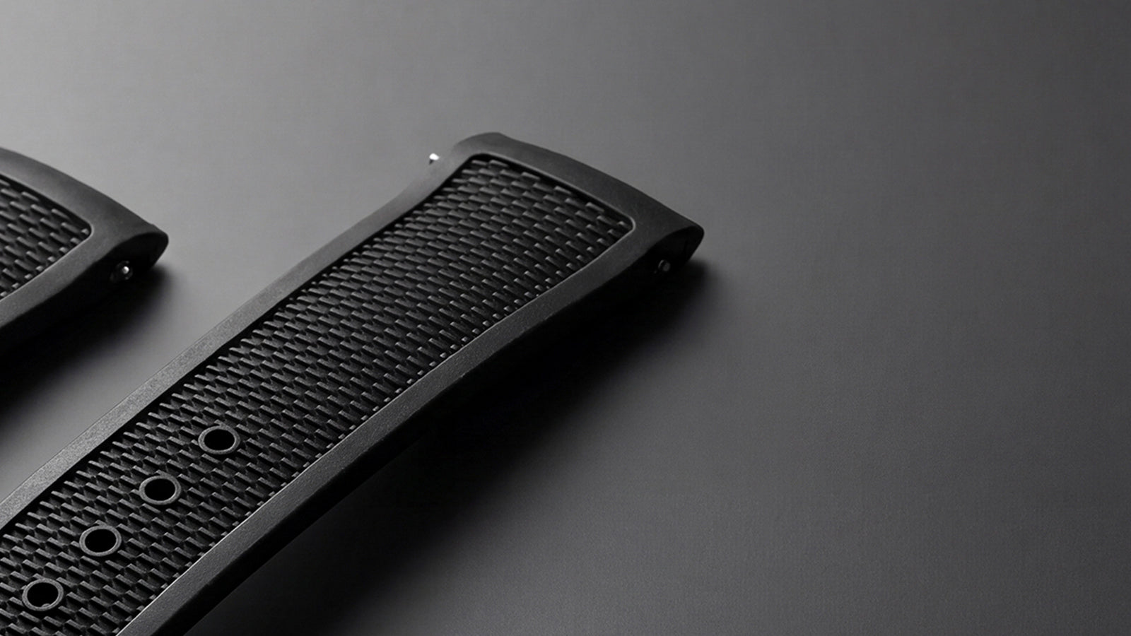 Close-up of the Timex Atelier black NBR synthetic rubber strap highlighting its textured surface, adjustment holes, and integrated quick-release pin.