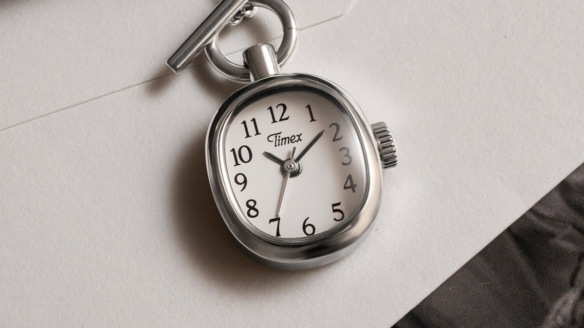 TW6A17600 Close-up of the Cavatina® Mini watch pendant with a white dial, black Arabic numerals, and polished stainless steel case.