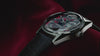 Video showcasing the Q Timex® Red Vega 1978 Reissue watch, highlighting the red and black patterned dial, day-date window, stainless steel case, domed crystal, and black leather strap.