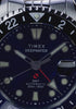 Scuba diver swimming above a colorful coral reef while wearing the Timex Deepwater Meridian 200 Automatic GMT, highlighting its dive-inspired design and 200-meter water resistance.