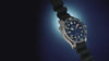 Rotating views of the blue Deepwater Meridian 200 HEV Automatic with a black rubber strap against a dark blue background.