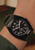 Timex Expedition® Capstone watch promotional video showcasing its rugged outdoor design. The video opens with close-up shots of the watch resting among dark textured rocks, emphasizing its brushed stainless-steel case, black dial, and olive green silicone strap.