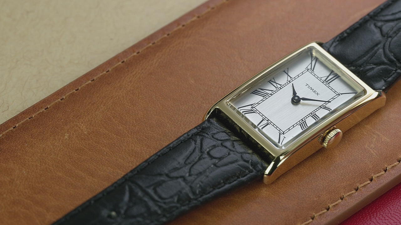 Video showcasing the Timex 1976 Lexington Reissue with rotating close-ups of the gold-tone rectangular case, Roman numeral dial, slim profile, and black leather strap in both lifestyle and product detail views.
